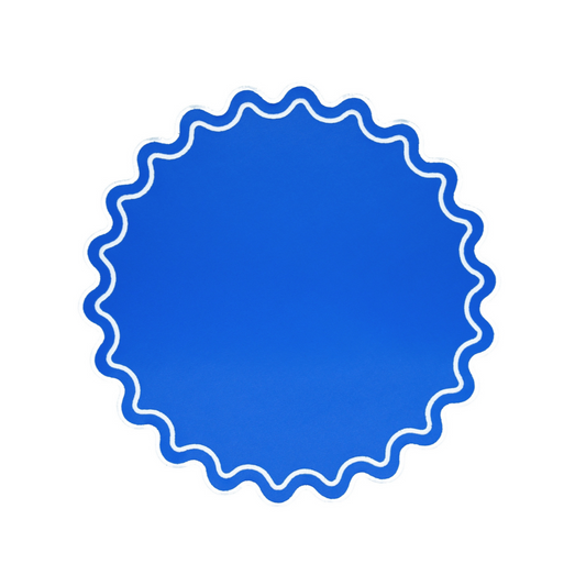 A blue faux leather placemat with a scalloped edge design.