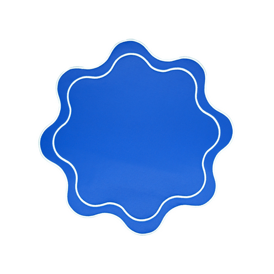 A blue faux leather placemat with a scalloped edge design on a white background.