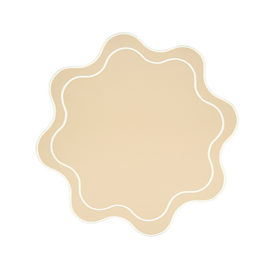 A beige faux leather placemat with a scalloped edge design.