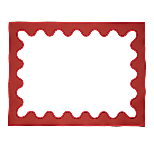 A red faux leather placemat with a scalloped edge design on a white background.