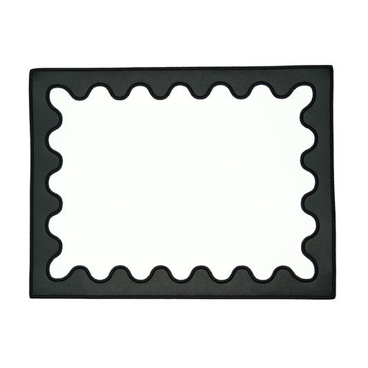 A rectangular black faux leather placemat with a decorative embroidered border.
