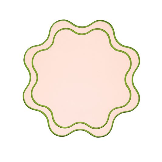 A round pink faux leather placemat with a textured surface and decorative edge.