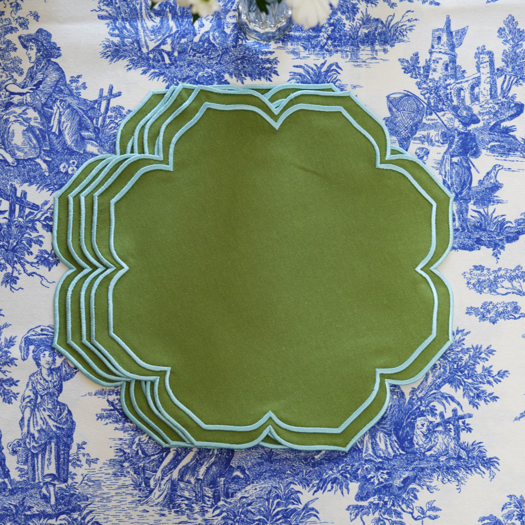 Green decorative plate on a blue and white toile patterned fabric