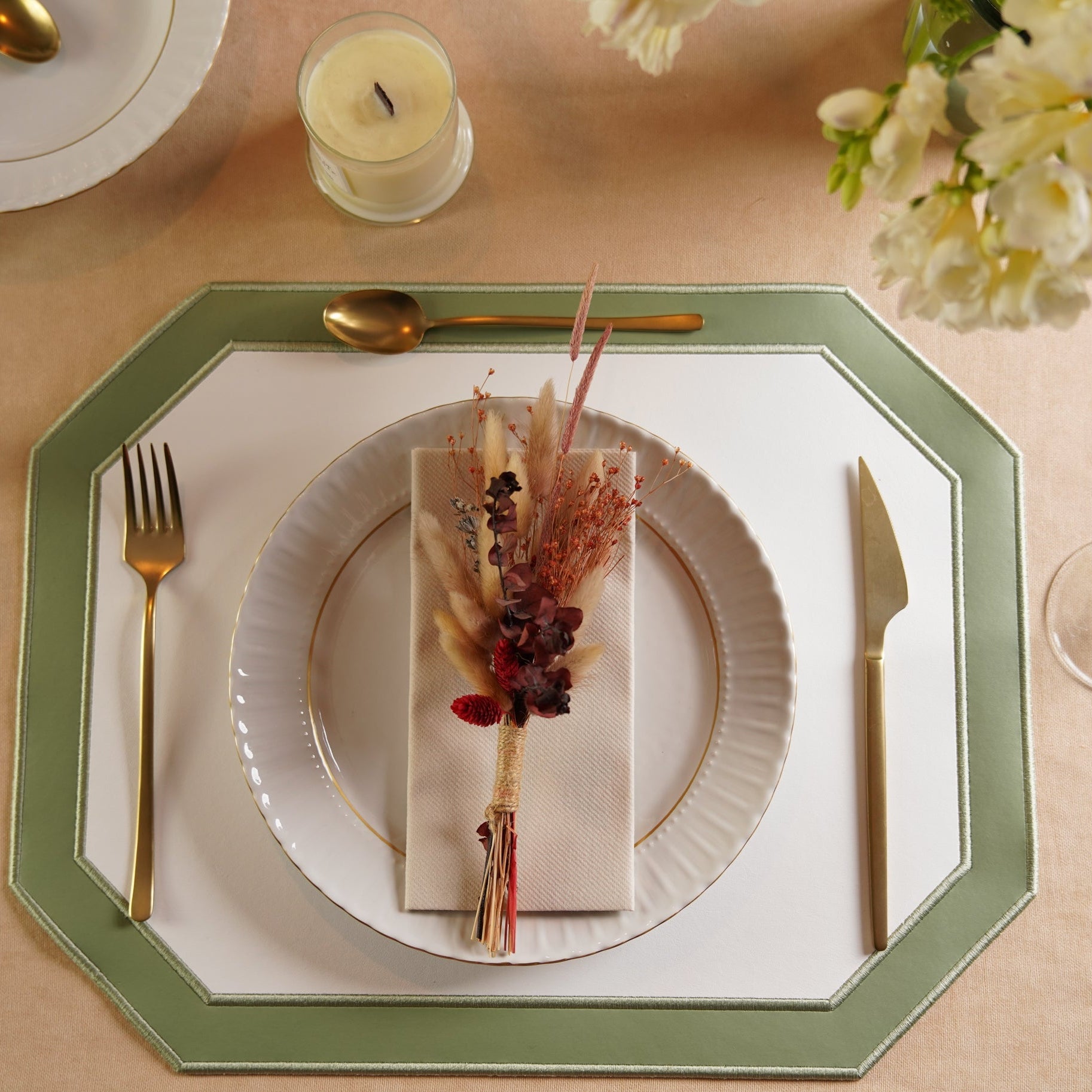 Elegant table setting with a decorative napkin and floral arrangement on a white plate.