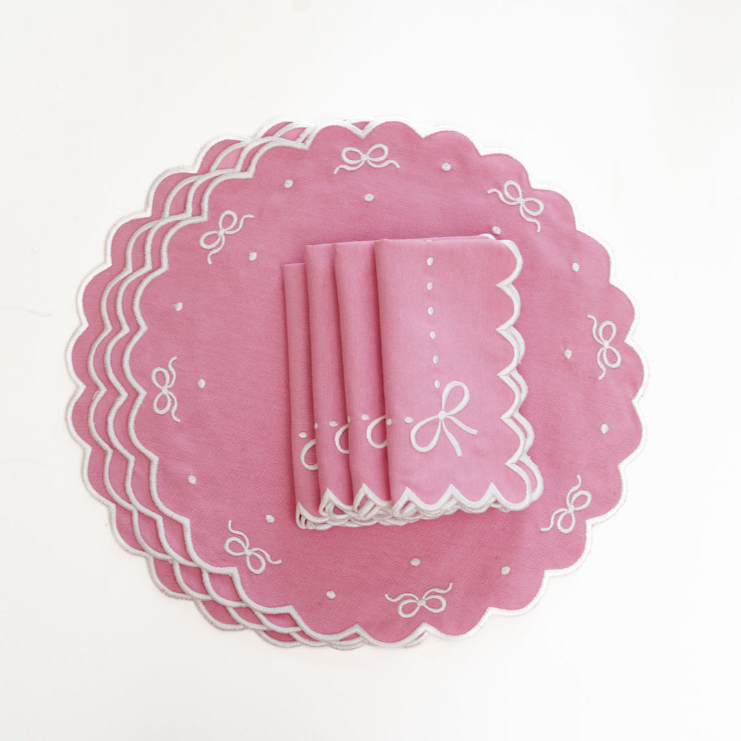 Set of pink paper plates with decorative white patterns on a white background