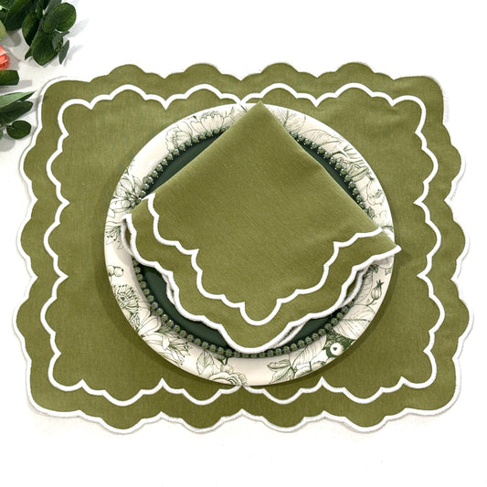 Green placemat with scalloped edge around a plate and napkin.