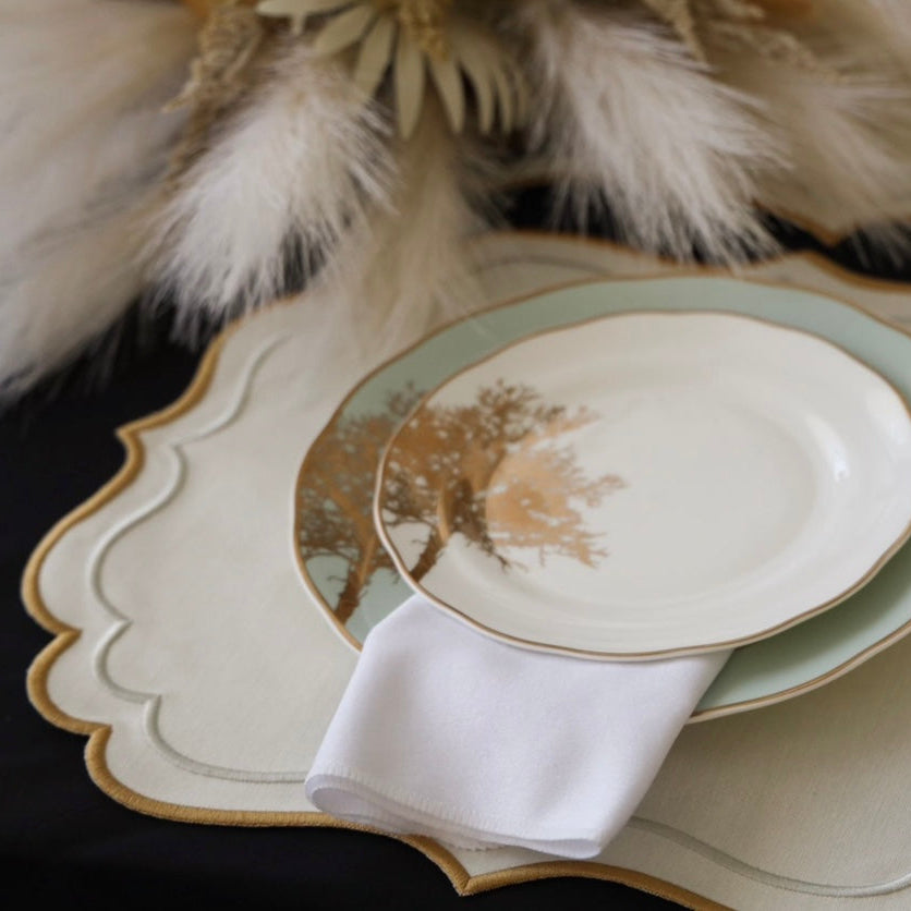 Decorative table setting with plates, napkin, and decorative elements on a dark surface.