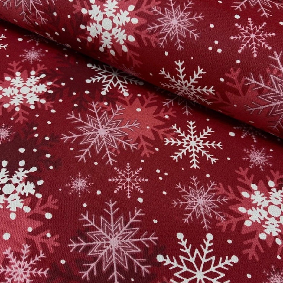 A red rectangular tablecloth with a white snowflake pattern.