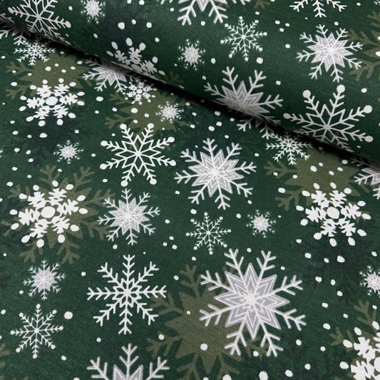 A green rectangular tablecloth with a white snowflake pattern.