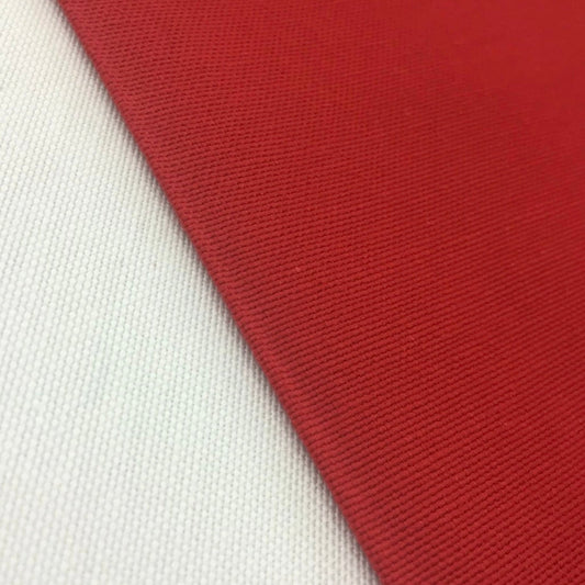 Close-up view of a red rectangular tablecloth with a white background, showcasing the fabric texture and solid color.