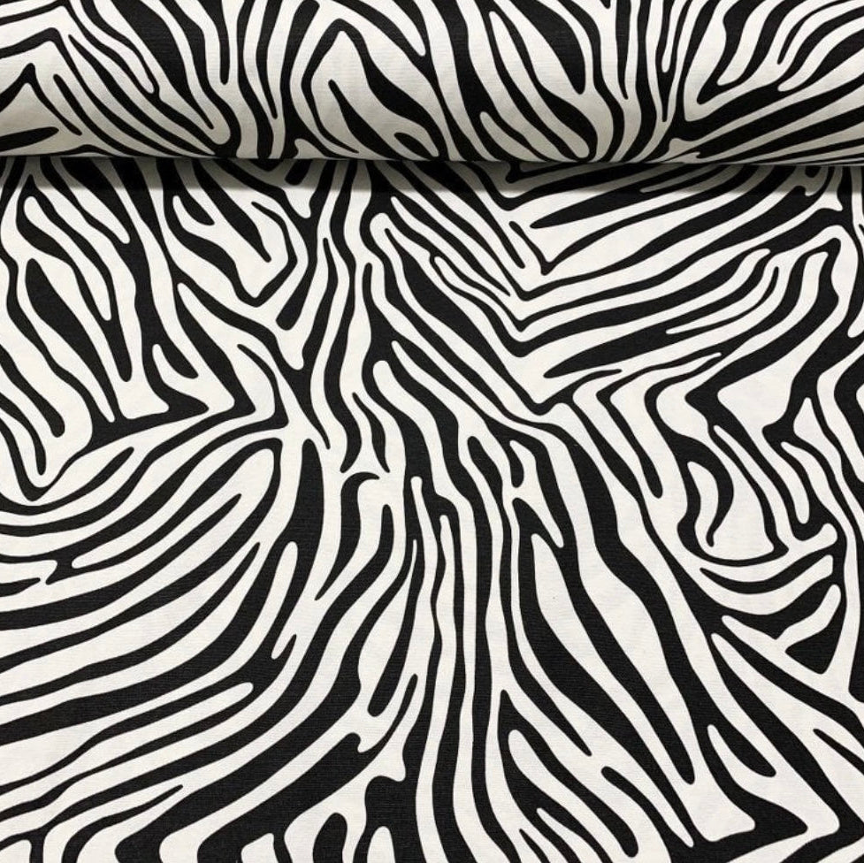 Close-up of a black and white zebra print tablecloth with a textured, water- and oil-repellent finish.