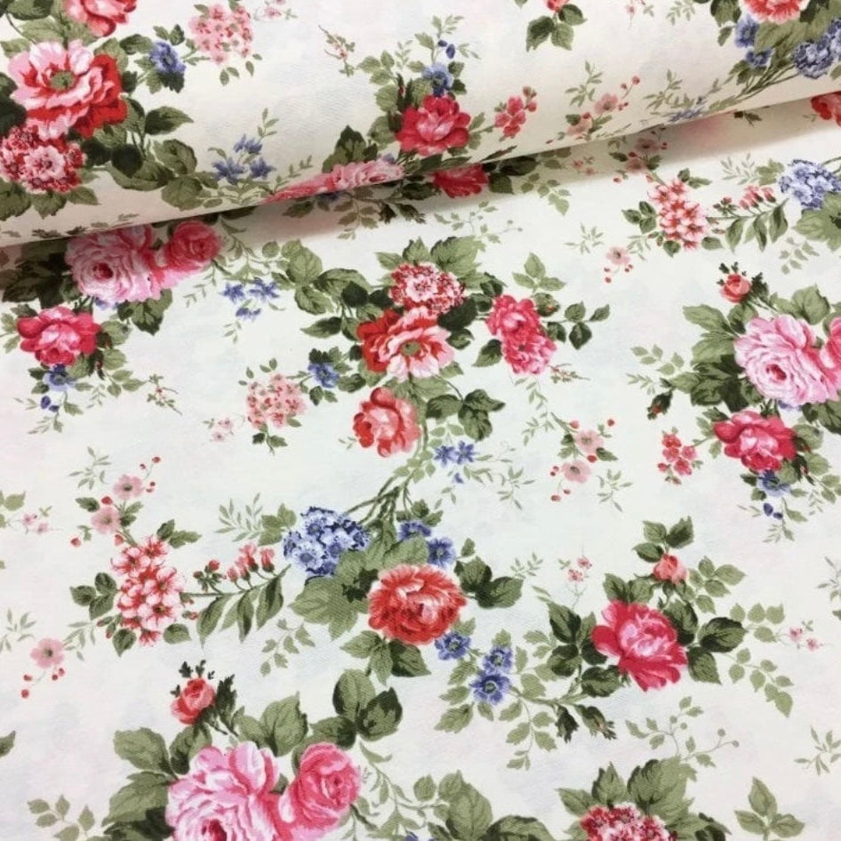 A rolled-up rectangular tablecloth with a red and white floral pattern on a beige background.