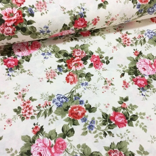 A rolled-up rectangular tablecloth with a red and white floral pattern on a beige background.