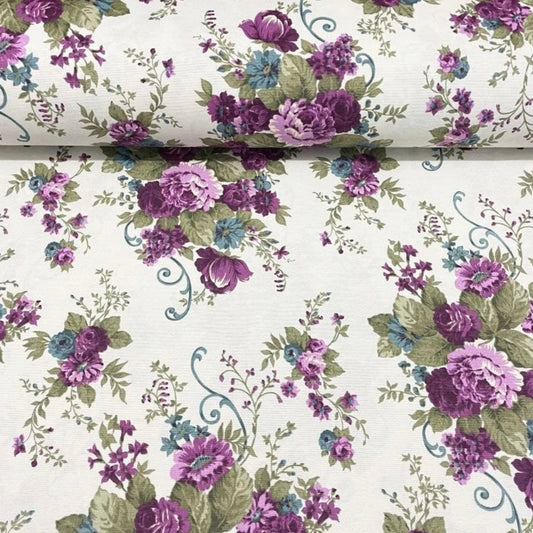 A floral patterned tablecloth with a purple and white color scheme, displayed on a flat surface.
