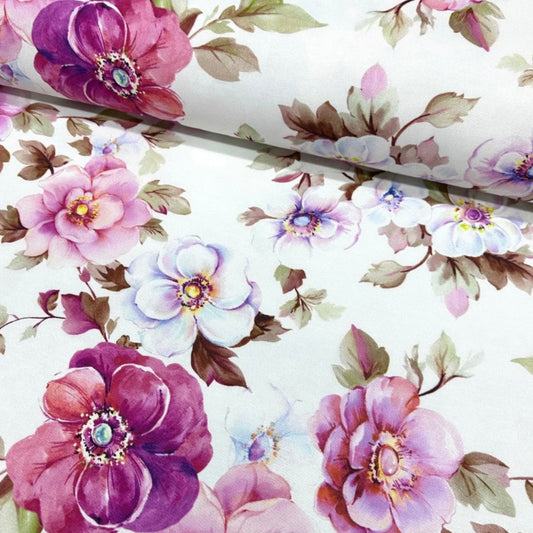 A rectangular tablecloth with a floral pattern featuring various shades of pink and purple flowers and green leaves on a white background.