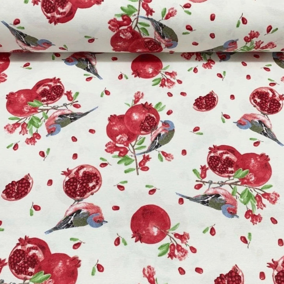 A rectangular tablecloth with a red and white pomegranate pattern and birds.