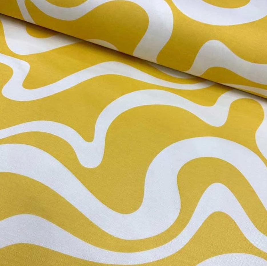 Close-up view of a yellow and white geometric patterned tablecloth.