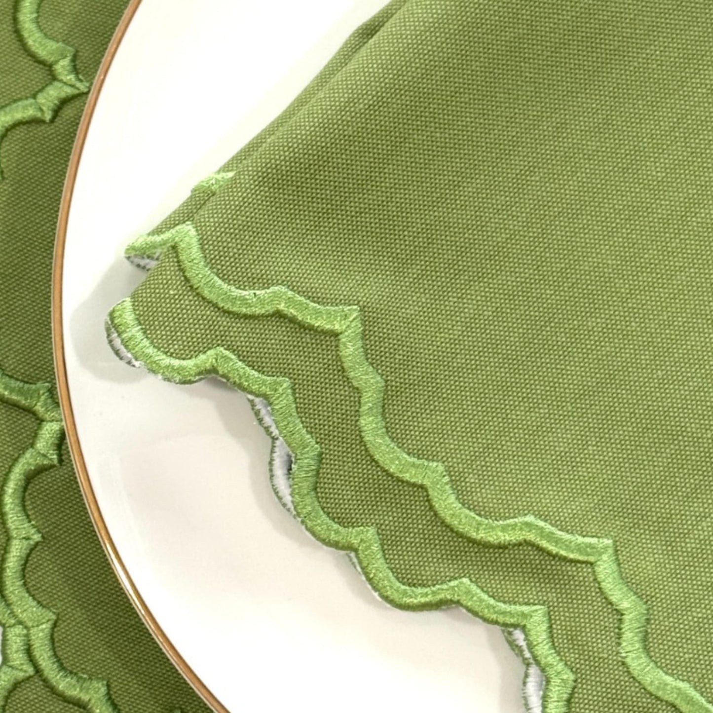 Green fabric with scalloped edge on a white background