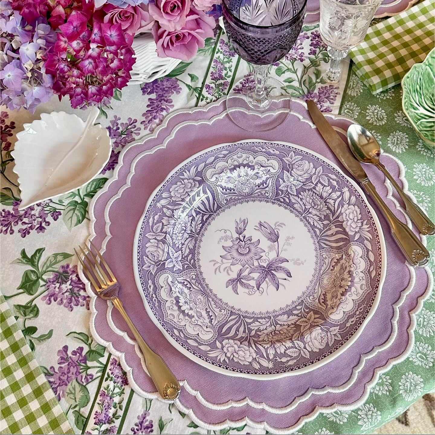 Decorative table setting with floral arrangements and patterned plates.