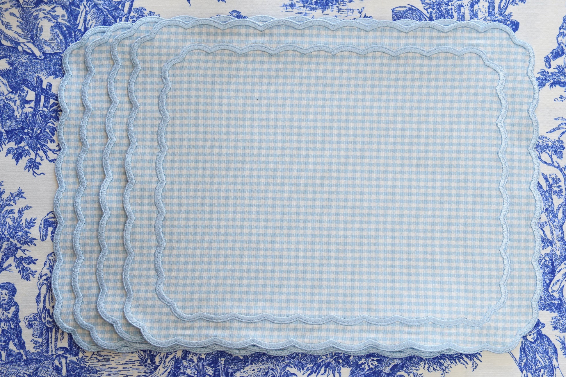Set of blue checkered placemats on a decorative blue and white background
