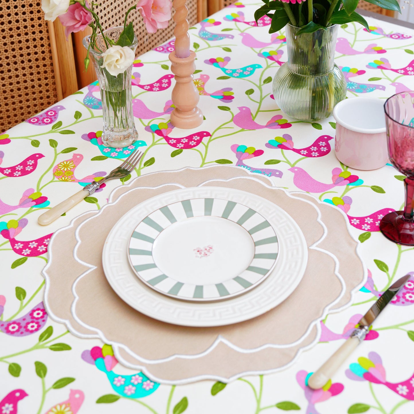Decorative table setting with floral centerpieces and a colorful tablecloth.