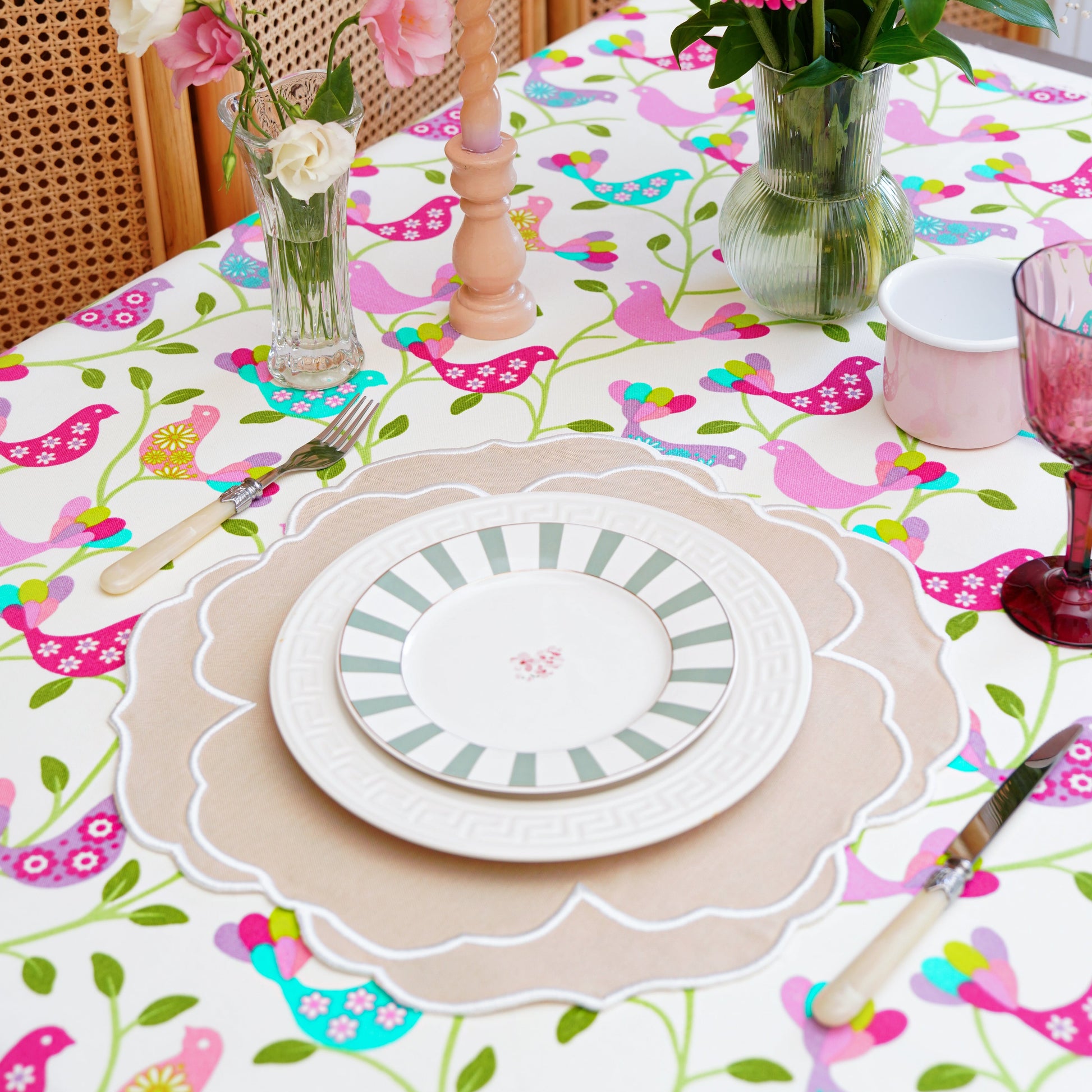 Decorative table setting with floral centerpieces and a colorful tablecloth.