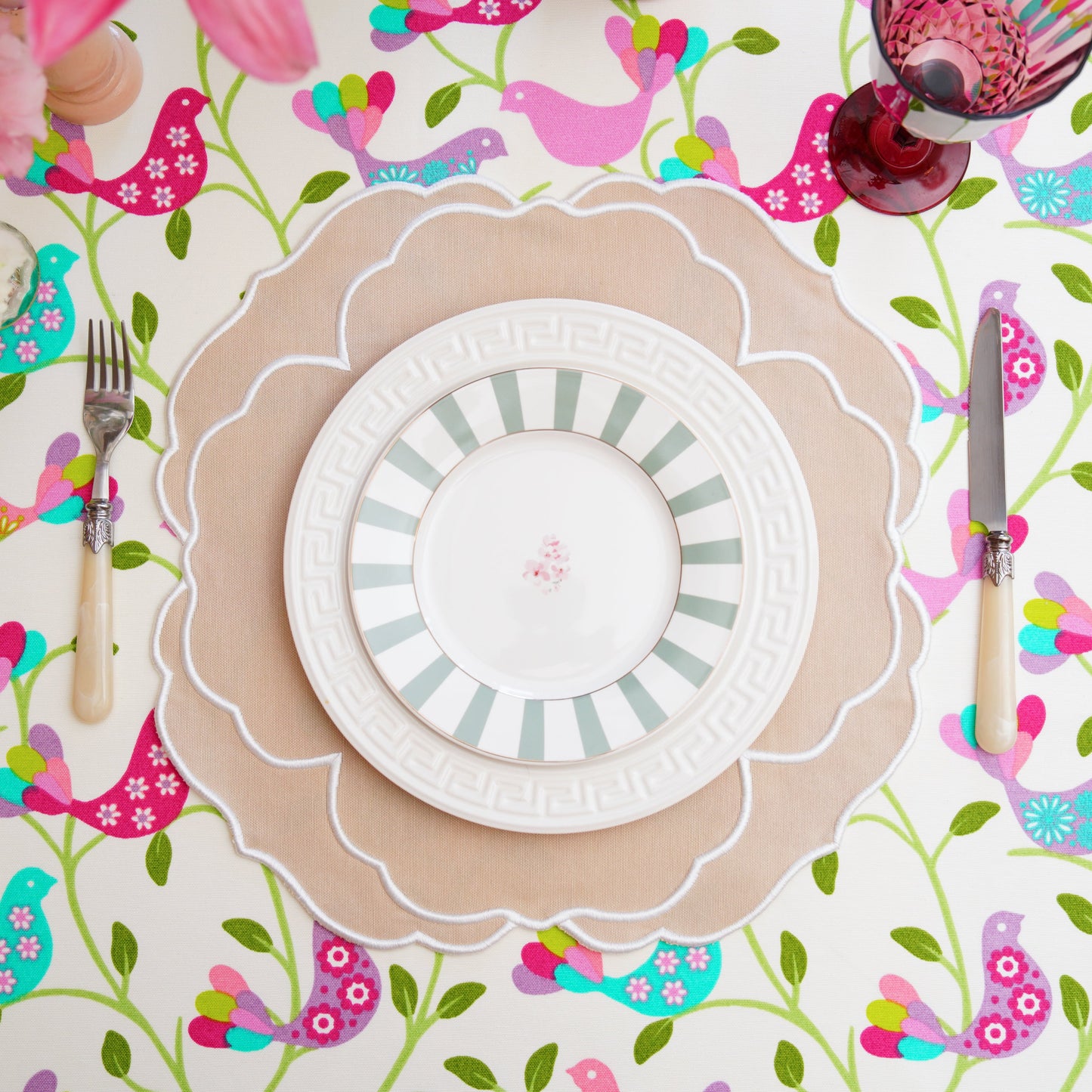 Colorful table setting with a patterned tablecloth, plates, and cutlery.