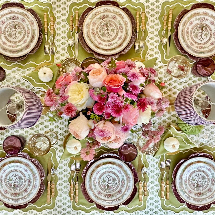 Decorative table setting with floral centerpiece and patterned tablecloth