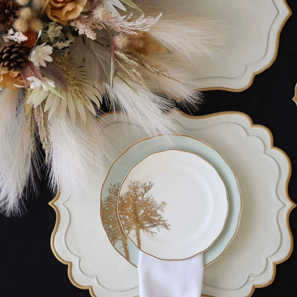 Decorative table setting with plates, napkin, and floral arrangement on a black background