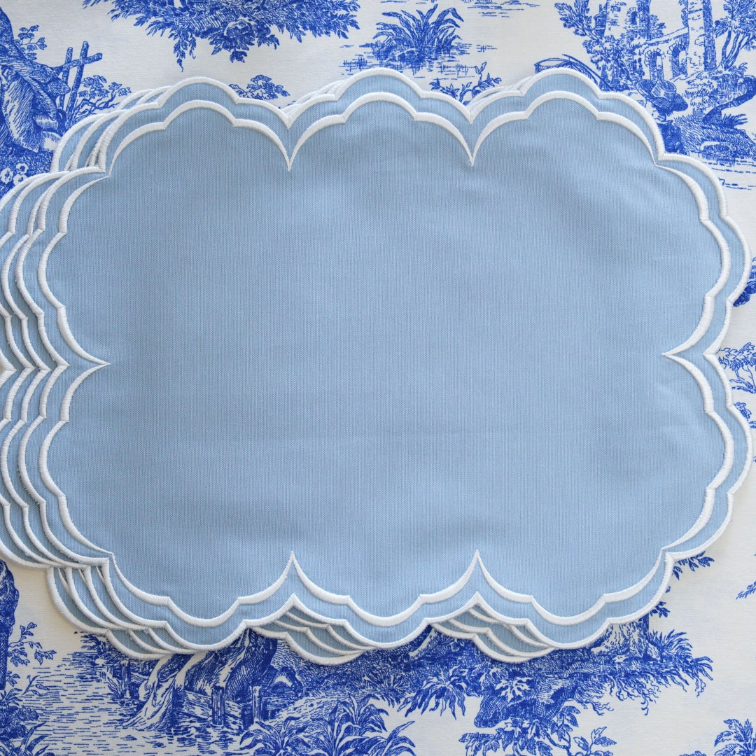 Set of blue scalloped plates on a blue and white toile background