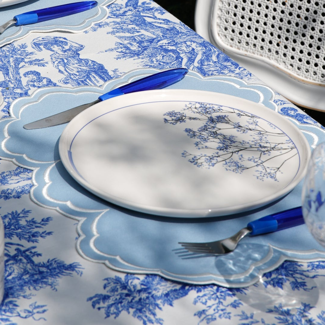 Dining table set with blue and white, cutlery, and a candle.