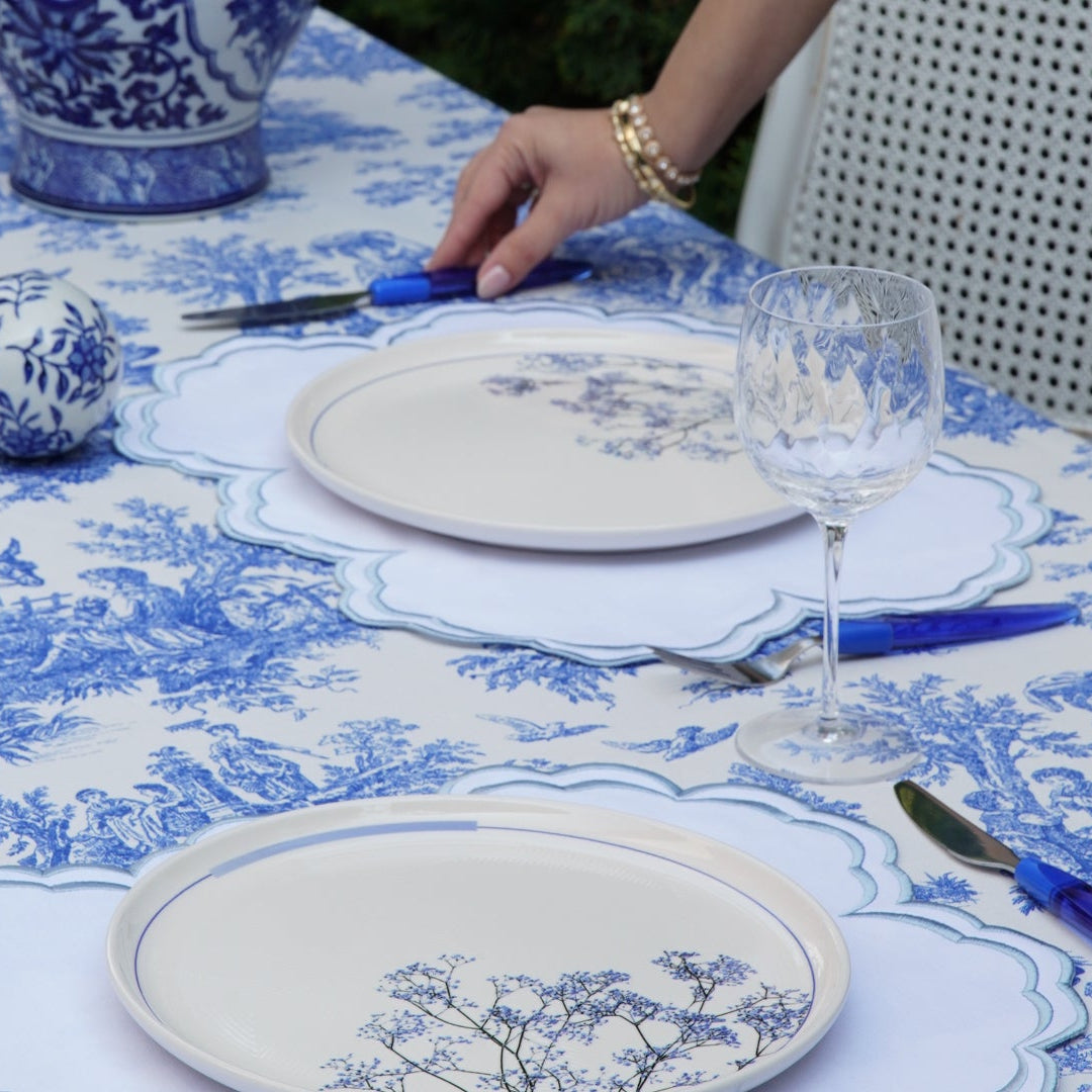 Dining table set with blue and white patterned plates and cutlery.