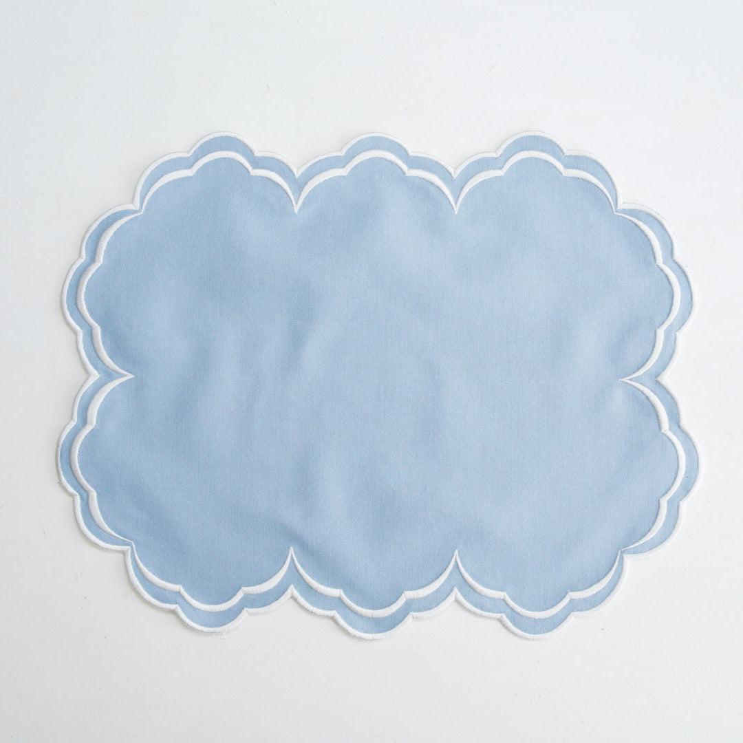 Light blue scalloped placemat on a light gray background
