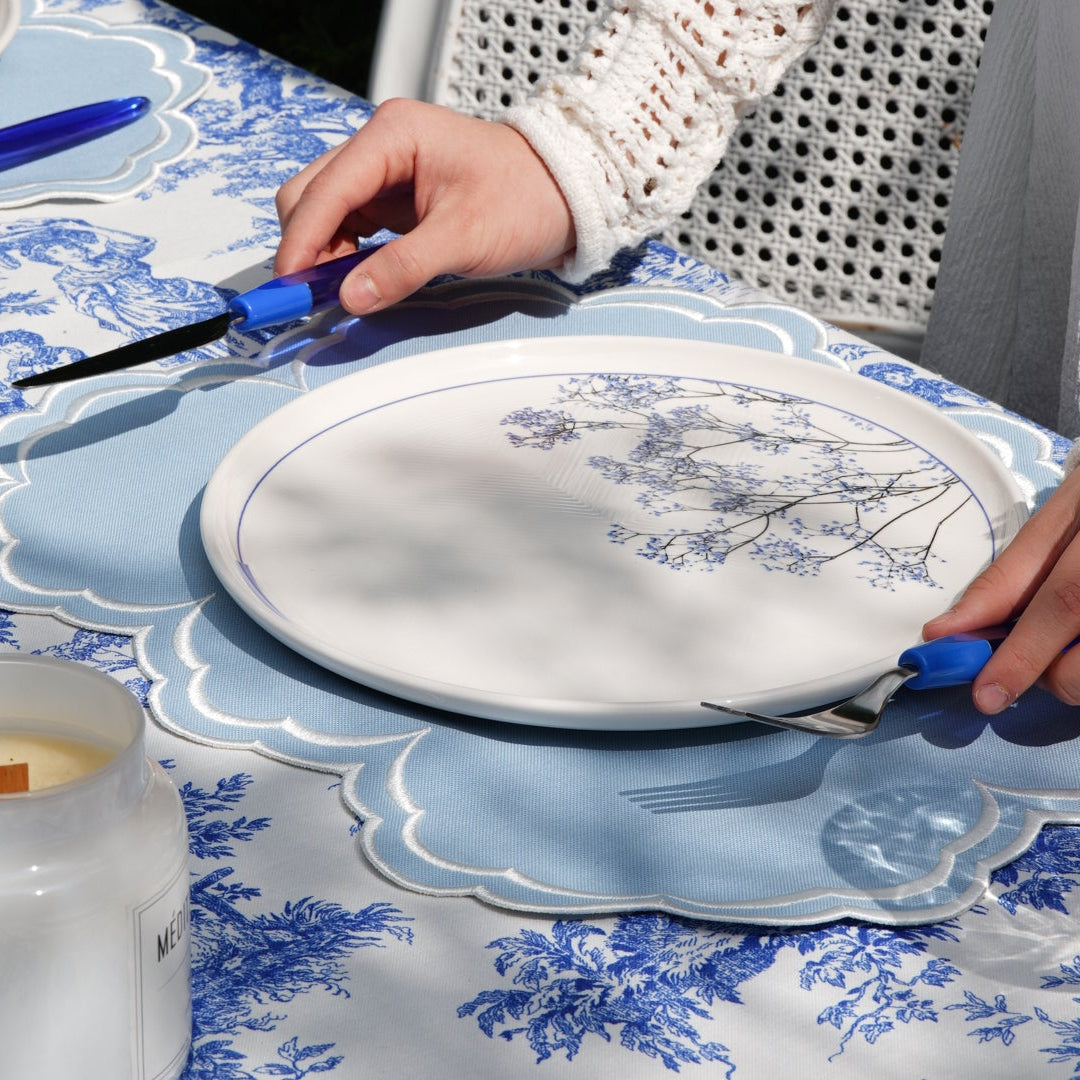 Person setting a table with blue and white china