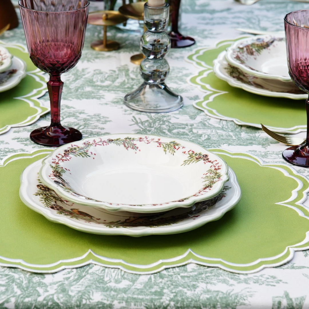 Elegant table setting with green placemats and pink glasses.