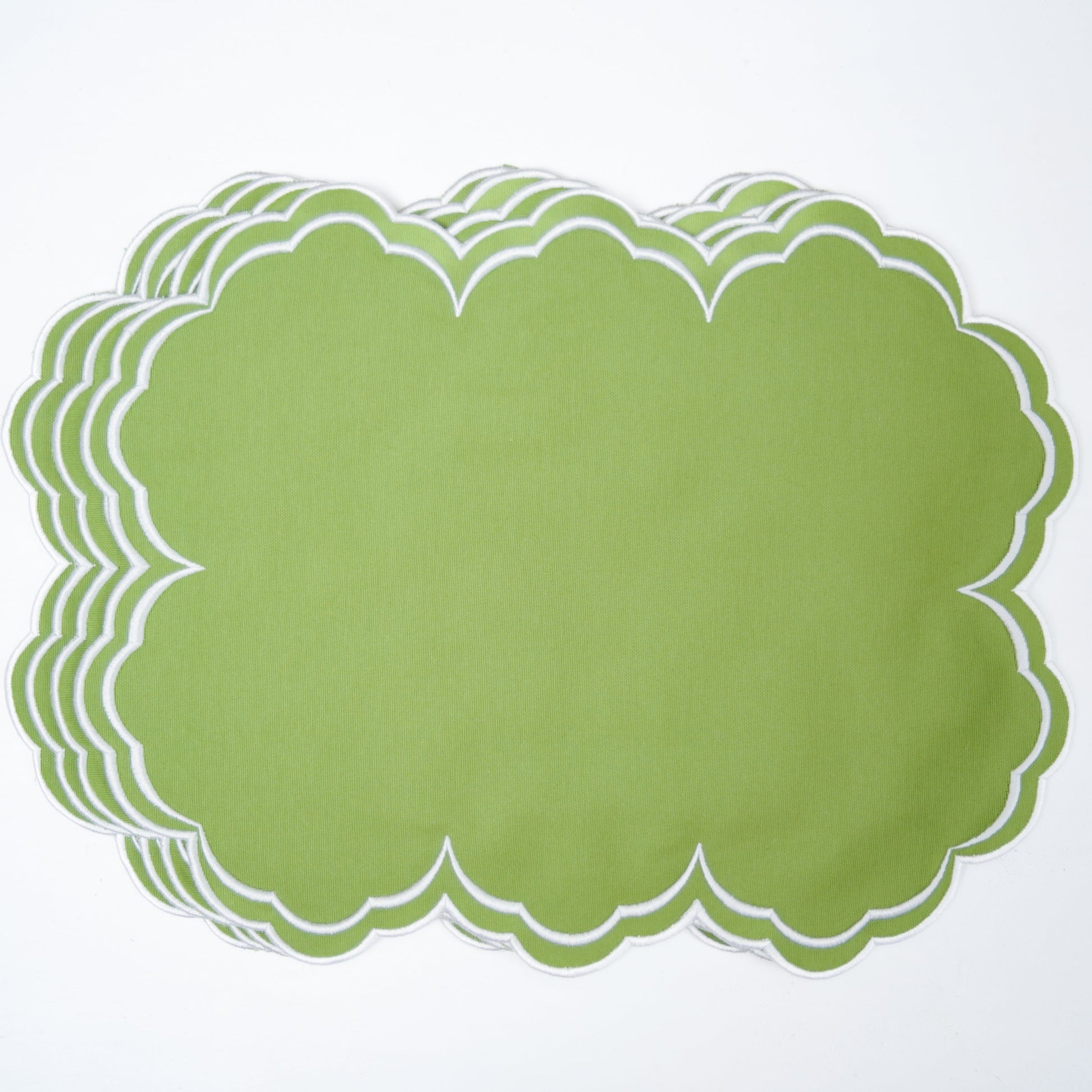 Stack of green paper placemats on a white background