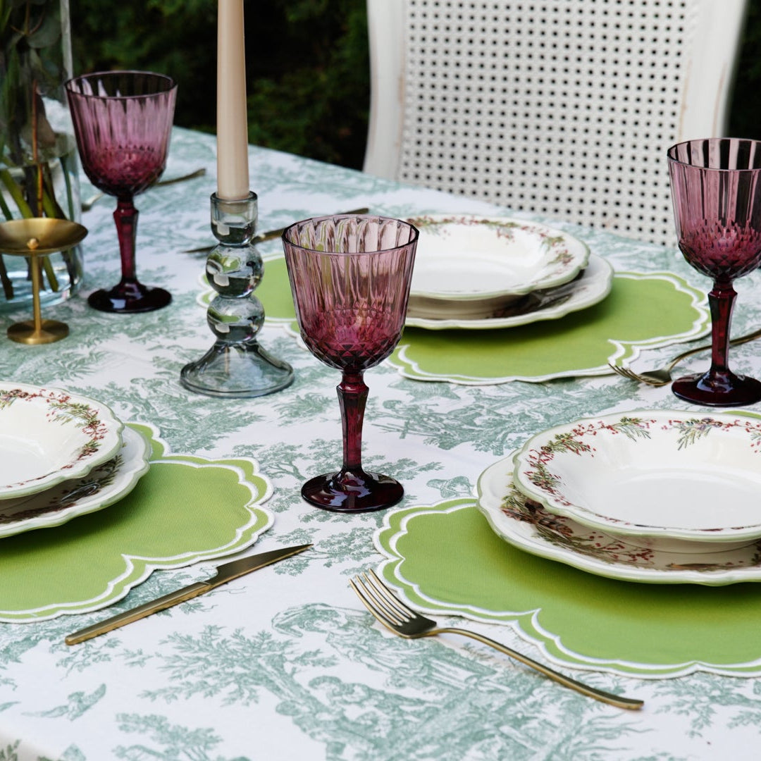 Elegant table setting with green placemats and purple glassware.
