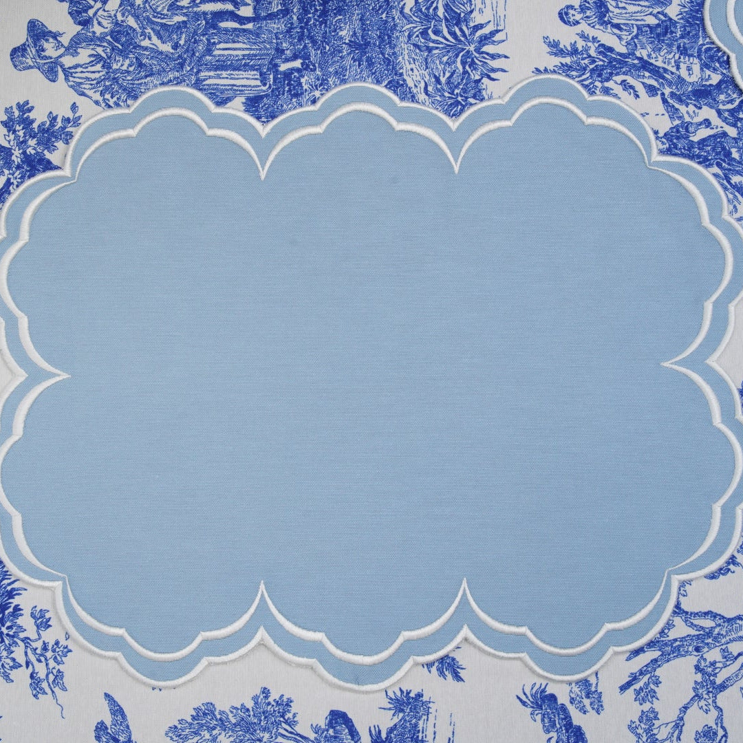 Blue and white patterned tablecloth with a scalloped placemat.