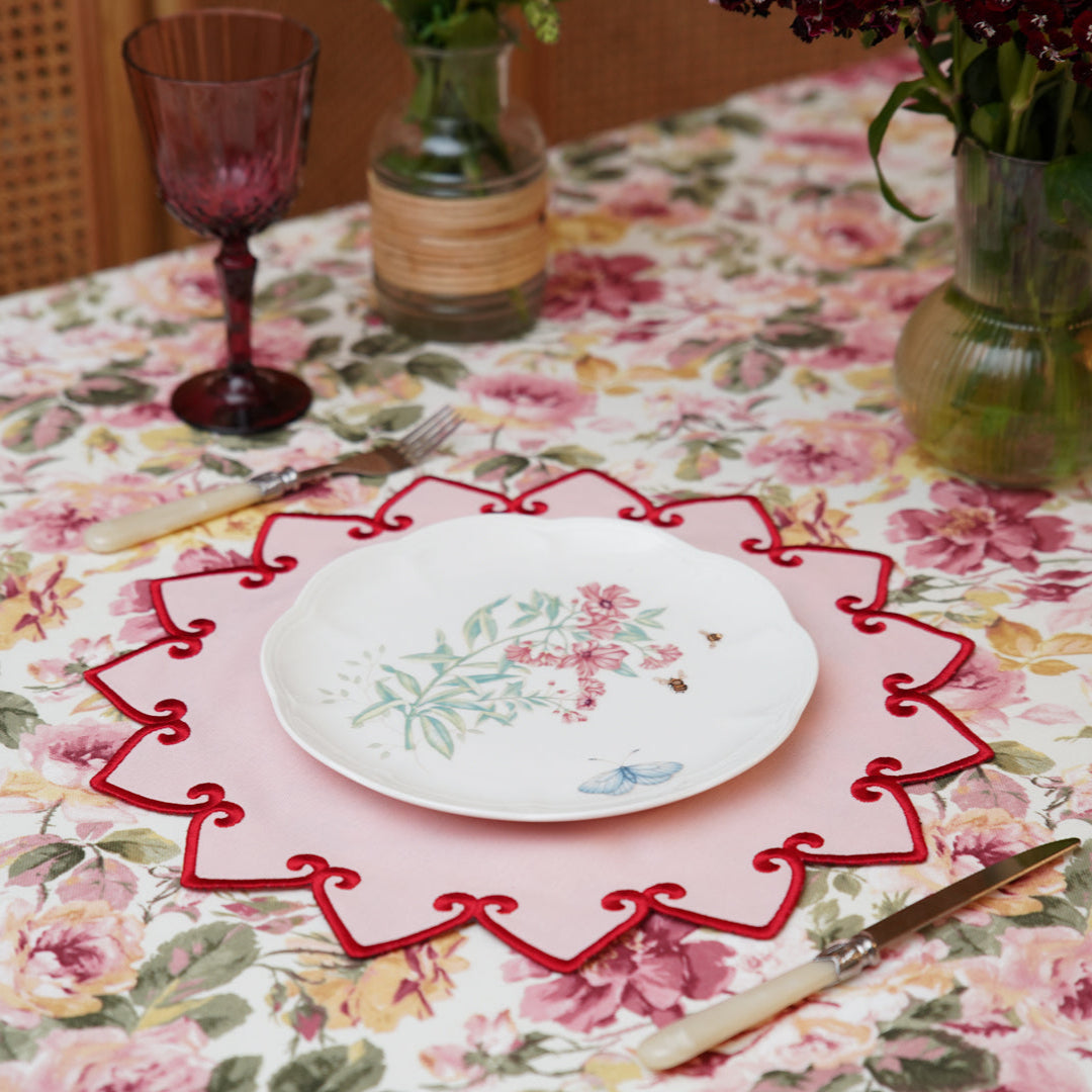 Set table with floral tablecloth and red decorative placemat