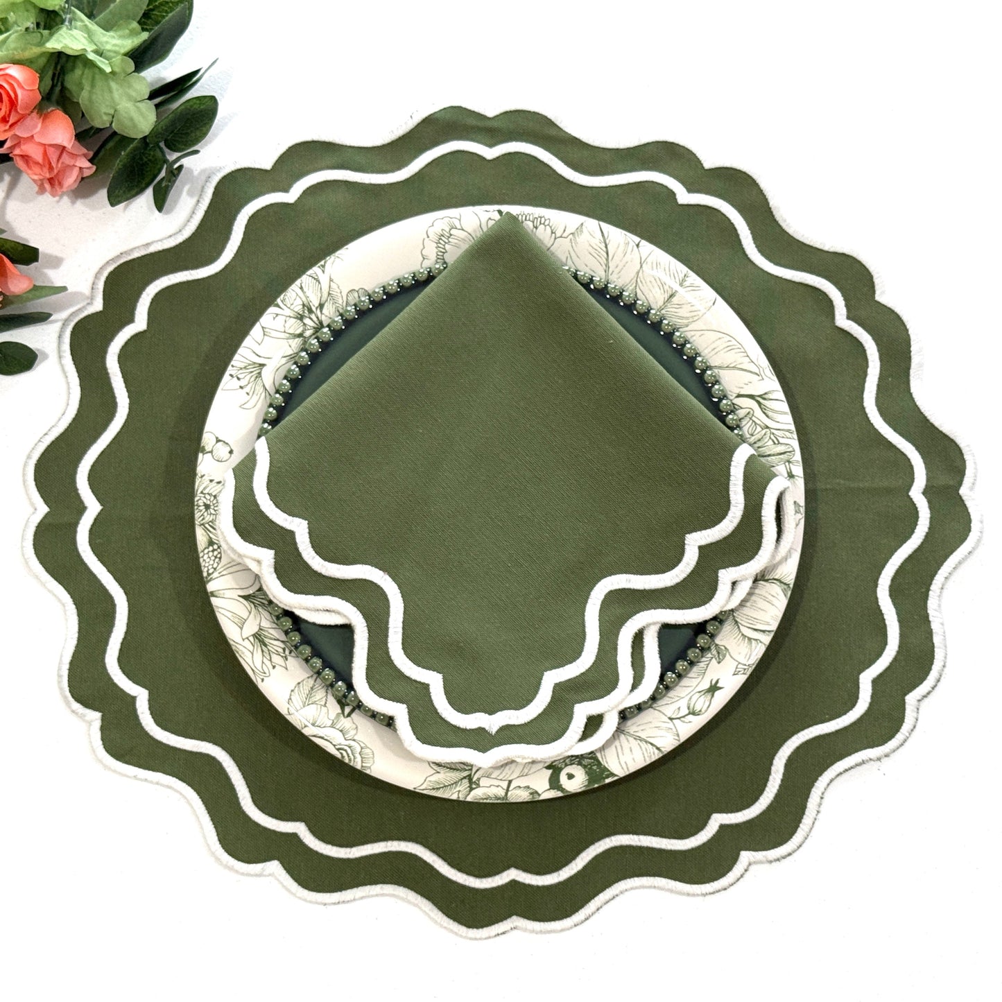 Green decorative plate with scalloped edge on a white background