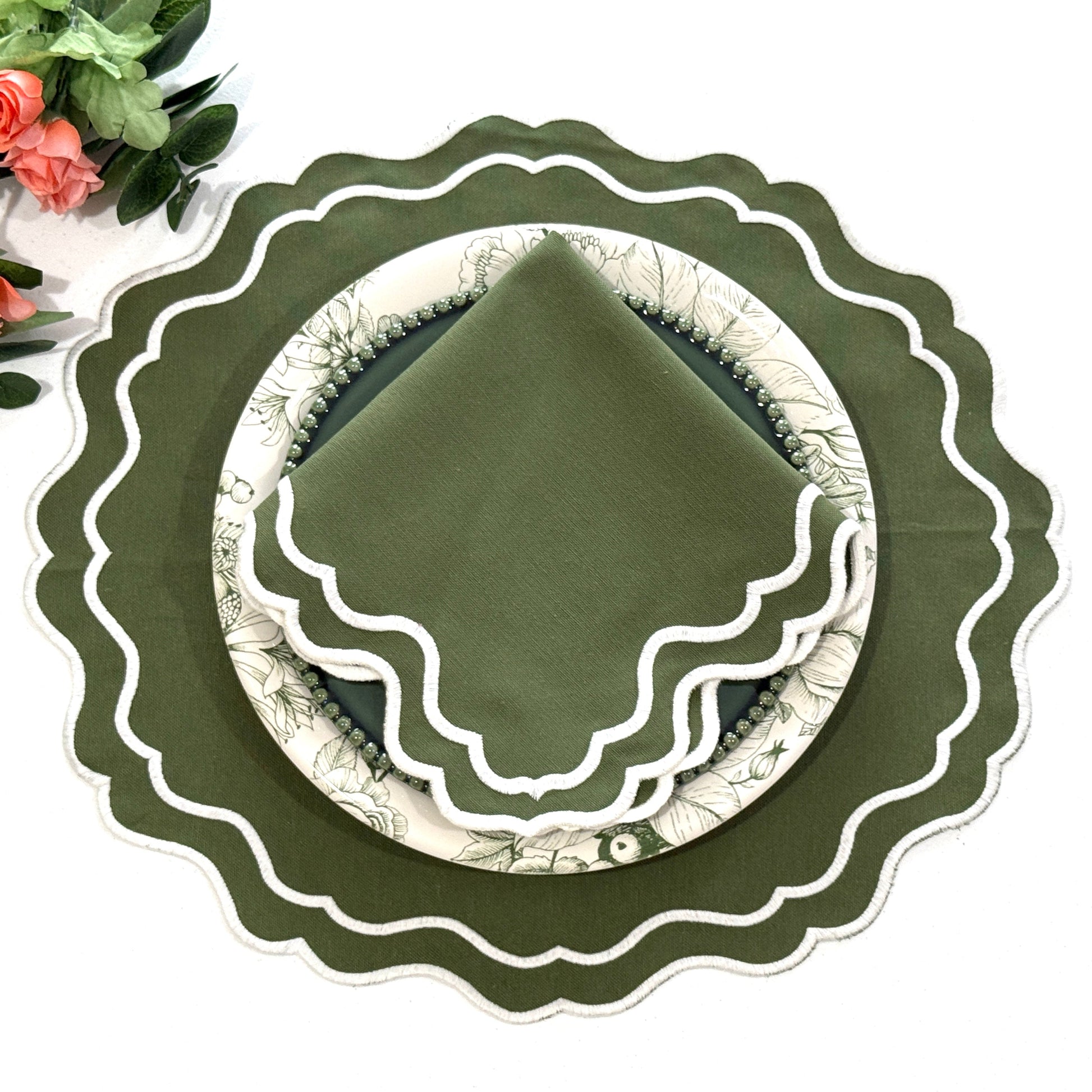 Green decorative plate with scalloped edge on a white background
