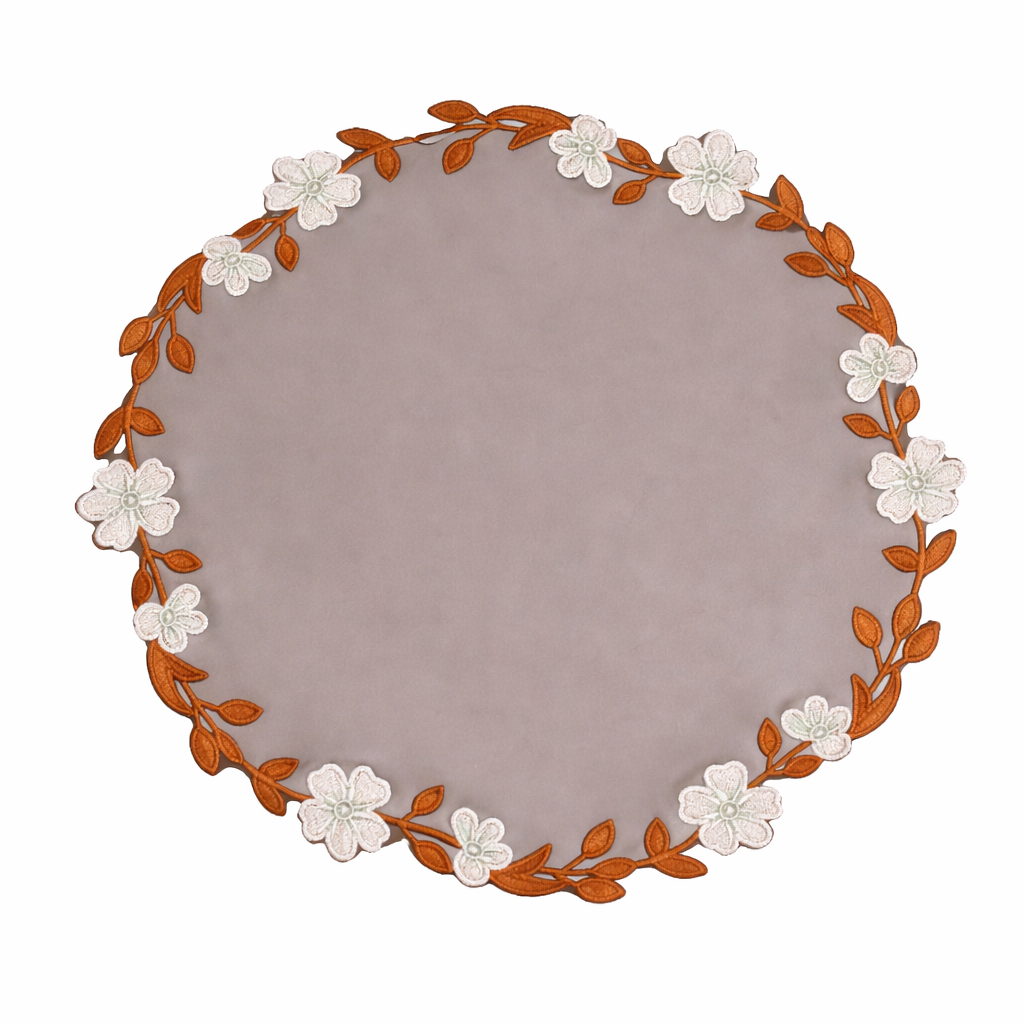 Round placemat with floral and leaf design on a white background