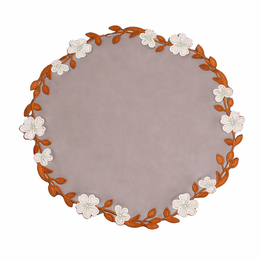 Round placemat with floral and leaf design on a white background