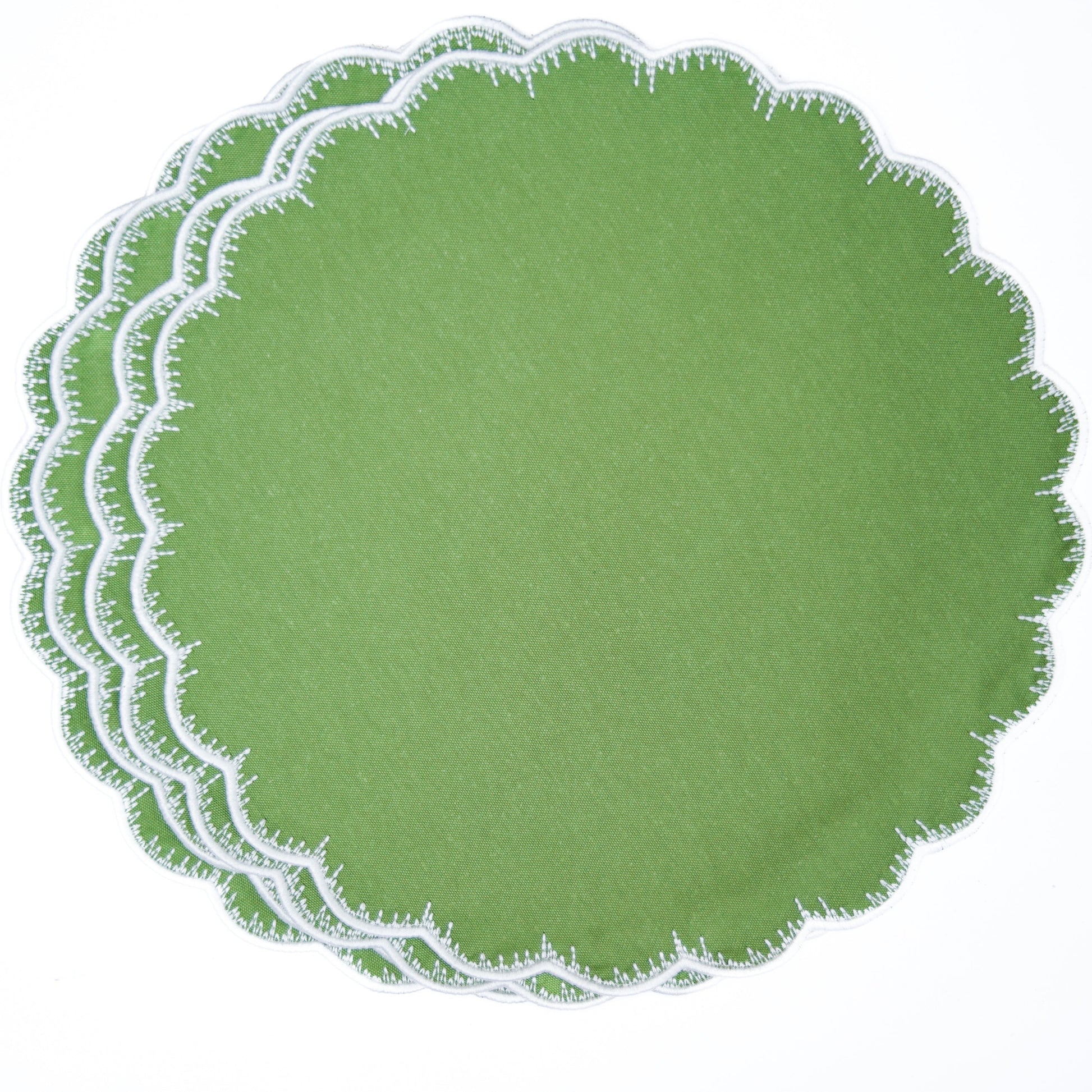 Set of green round placemats with scalloped edge on a white background