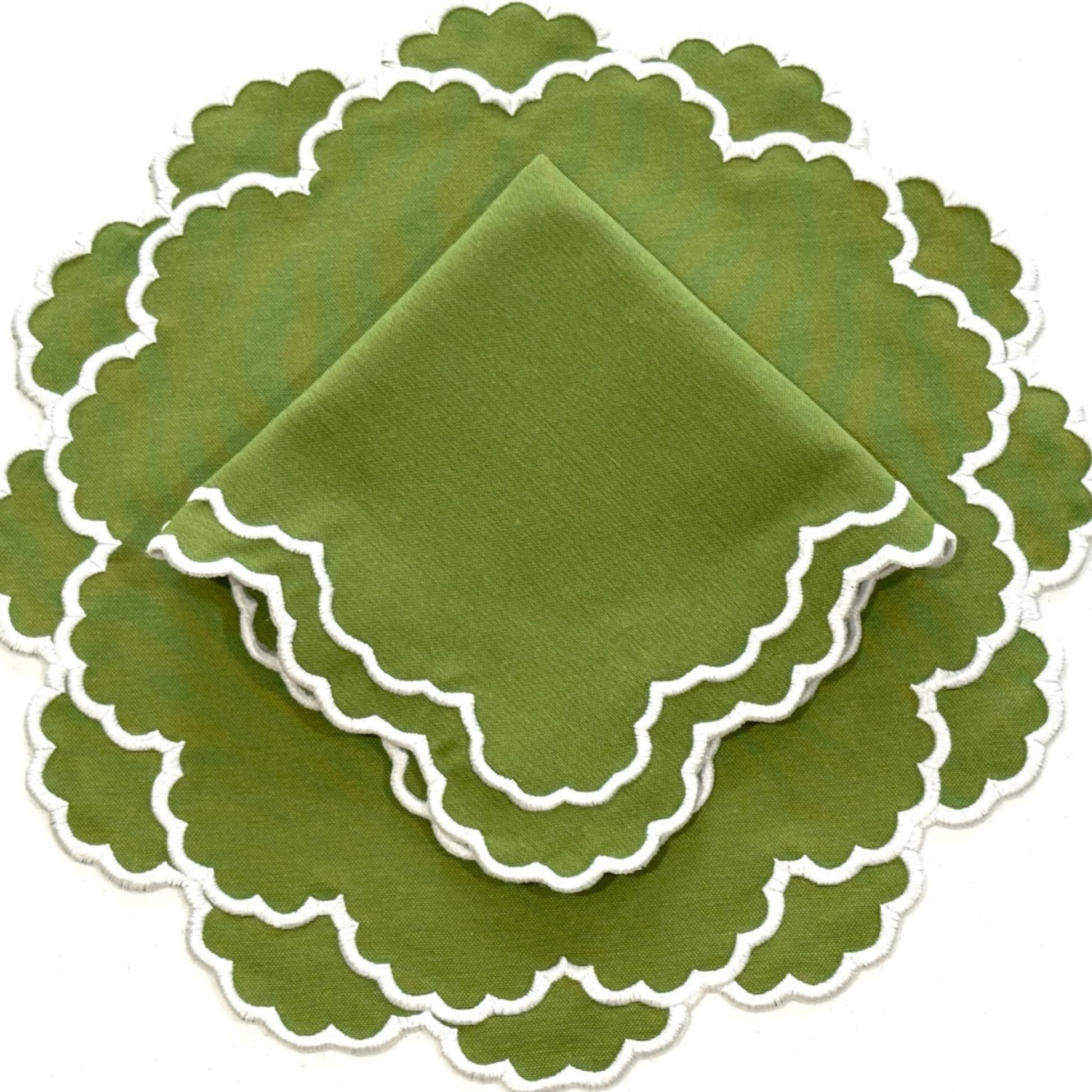 A set of green fabric placemats with a white embroidered edge, displayed stacked on top of each other.