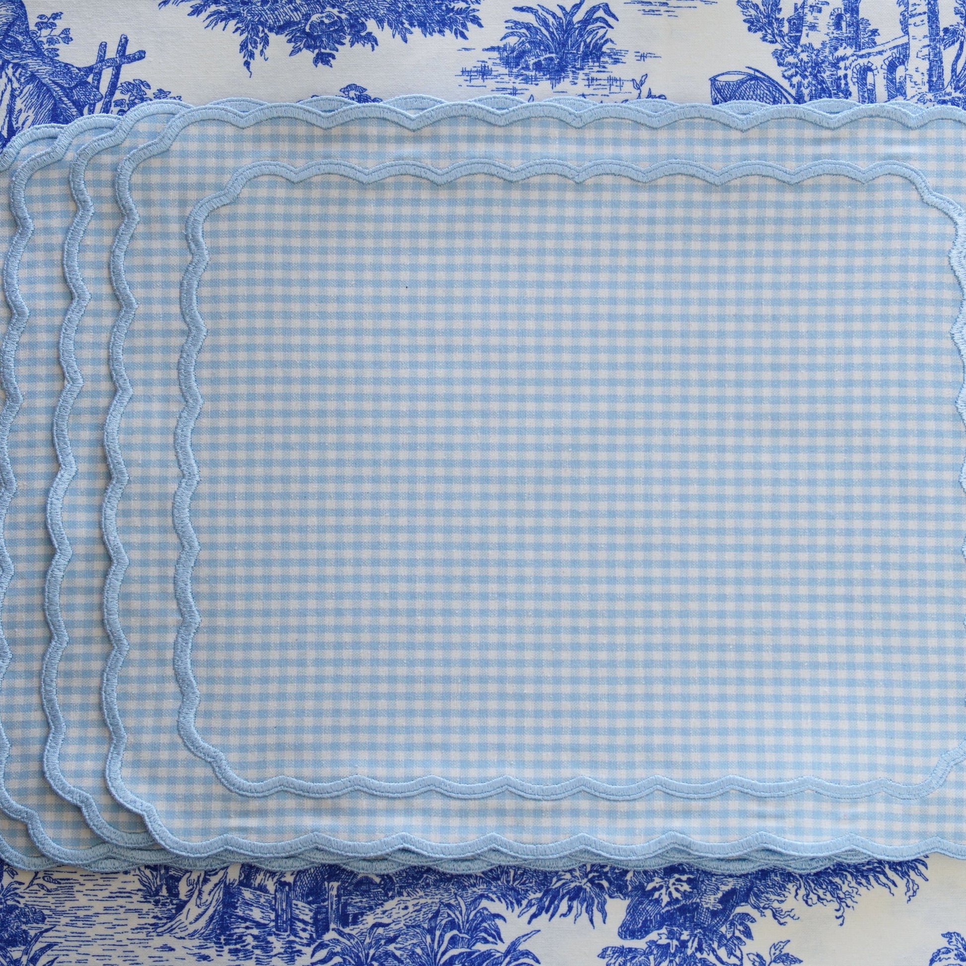 Set of blue checkered placemats on a decorative wallpaper background