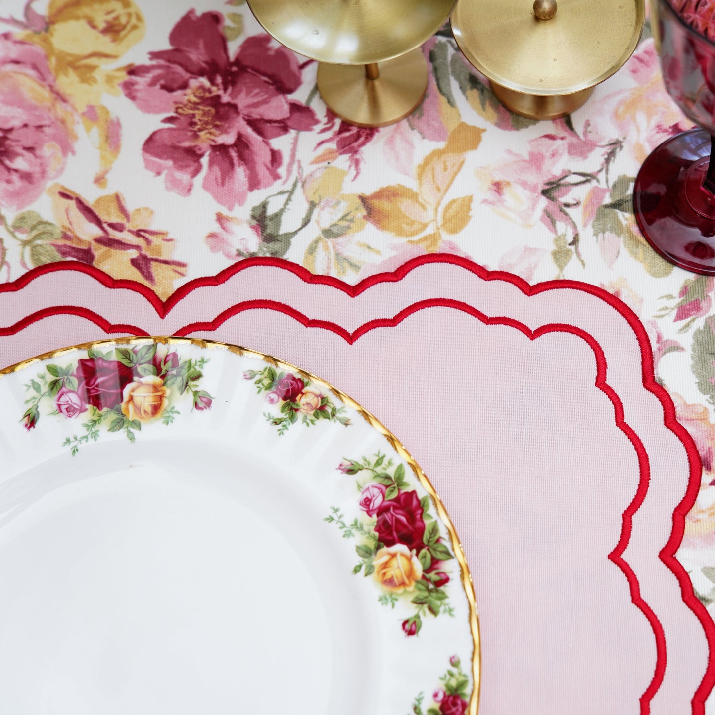 Detailed table setting with floral tablecloth and decorative plates.