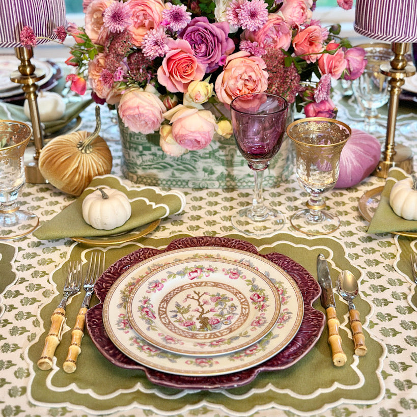 Decorative table setting with floral centerpiece, patterned plates, and elegant tableware.