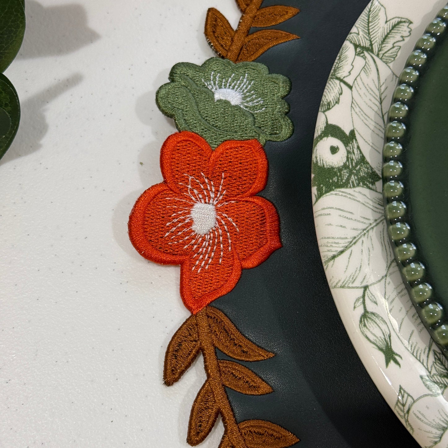 Decorative plate with floral and leaf patterns on a white background