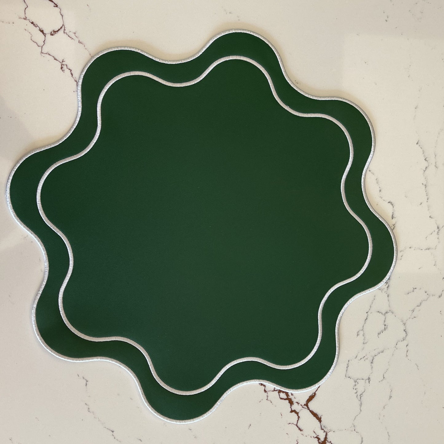 Decorative green plate with wavy edge on a textured beige background